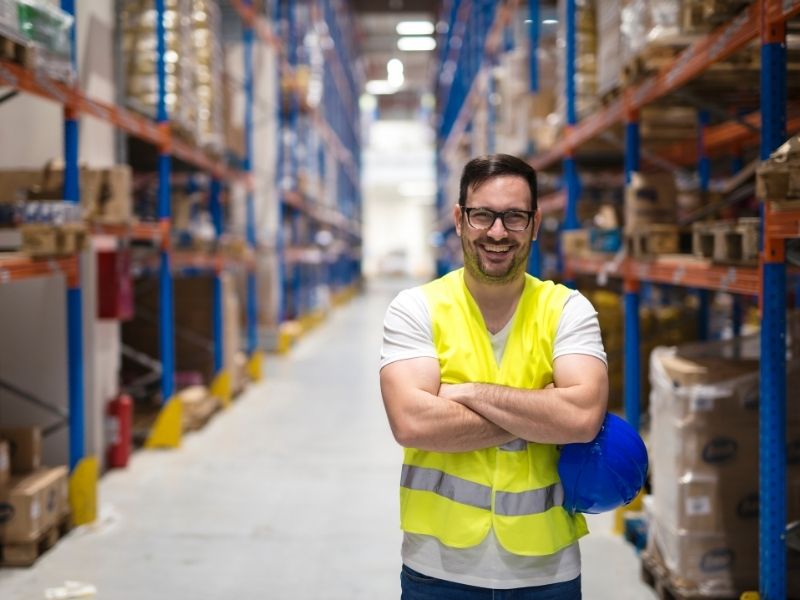 Logistics worker standing in warehouse aisle
