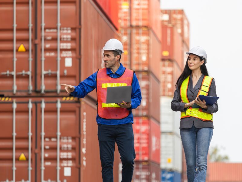 Workers handling cargo containers with inland marine insurance protection in place