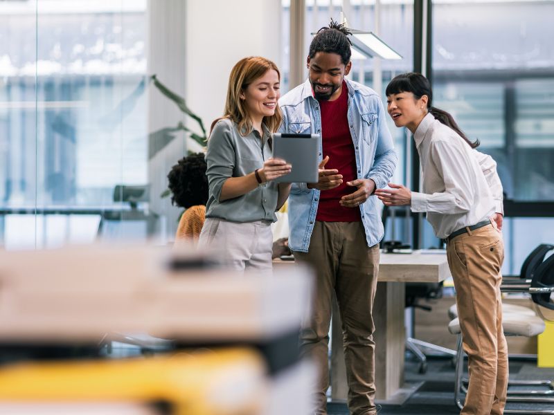 Diverse team reviewing payroll solutions on a tablet in a modern office, powered by ClearPalm in Florida.