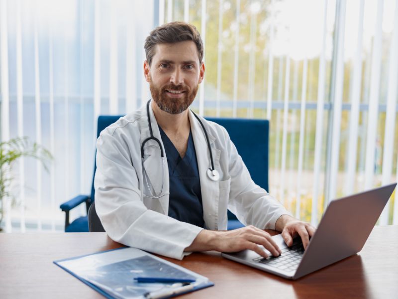 Healthcare professional managing business insurance on a laptop, protected by ClearPalm’s insurance solutions for medical practices in Florida. Warehouse supervisor training new employee