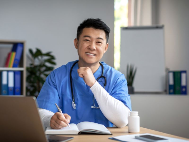 Healthcare professional managing payroll records at his desk, supported by ClearPalm's payroll solutions for medical practices in Florida.