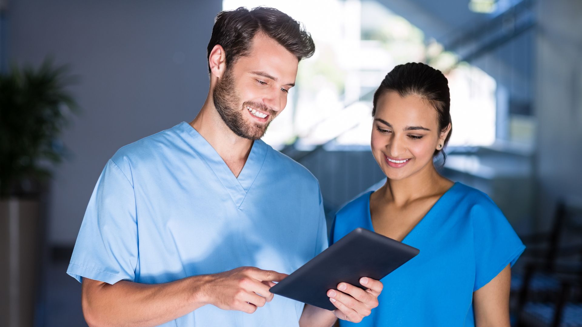 Healthcare workers reviewing payroll information on a tablet, supported by ClearPalm’s payroll solutions for medical businesses in Florida. Benefit brief employee app
