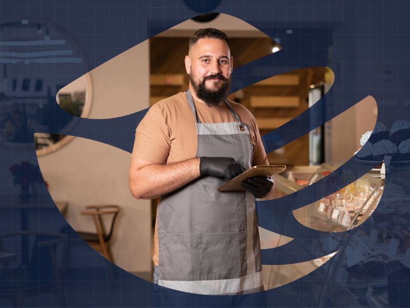 Restaurant owner holding a tablet in his kitchen, protected by ClearPalm’s general liability insurance for food service businesses Restaurant owner holding a tablet in his kitchen, protected by ClearPalm's general liability insurance for food service businesses