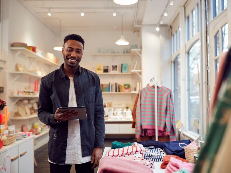 Small business owner managing his retail store with a tablet, supported by ClearPalm's payroll and business solutions in Florida.